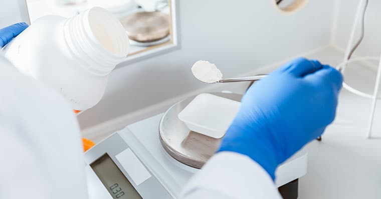 pharmacist weighing chemicals to mix in a compounding pharmacy